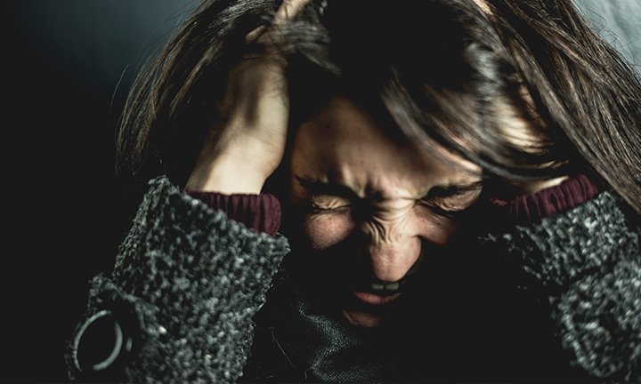 mulher tensa com as mãos na cabeça